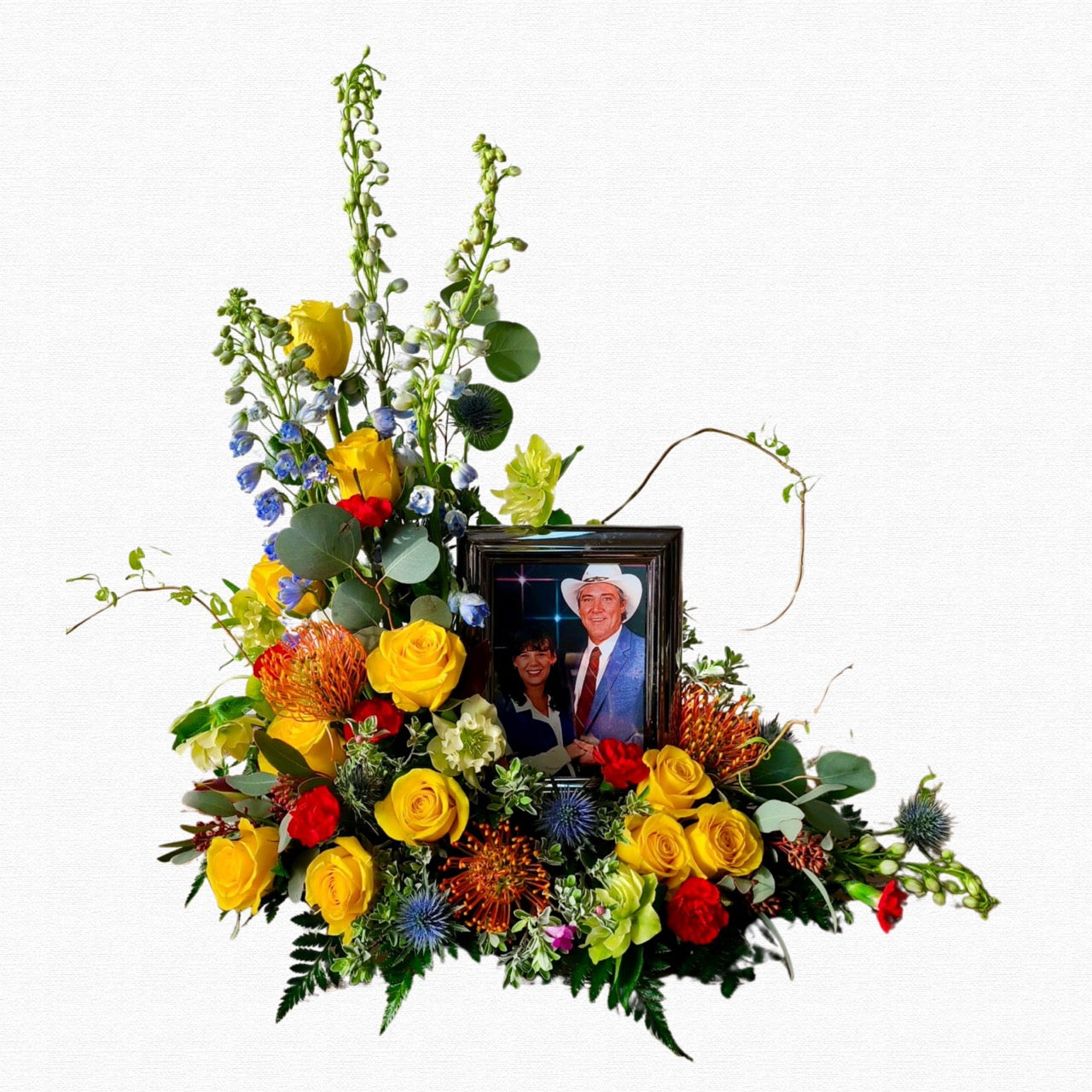 Vibrant sunset-colored funeral photo tribute arrangement by Historic Dade City Florist