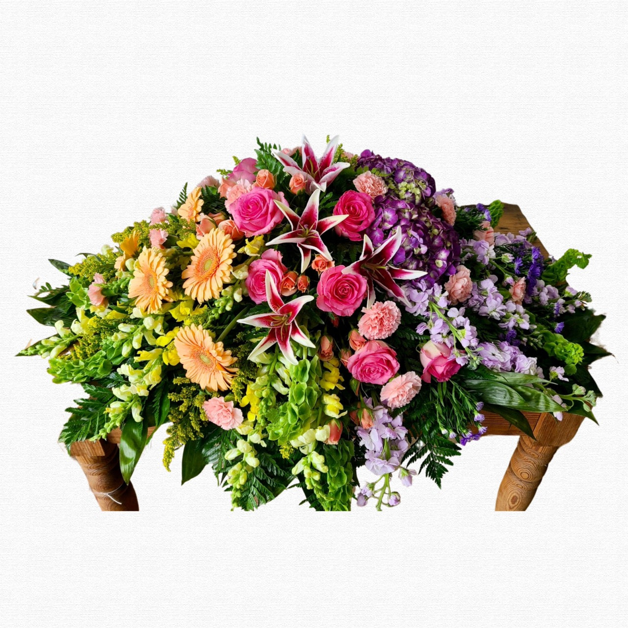 Multicolor funeral casket spray arrangement by Historic Dade City Florist